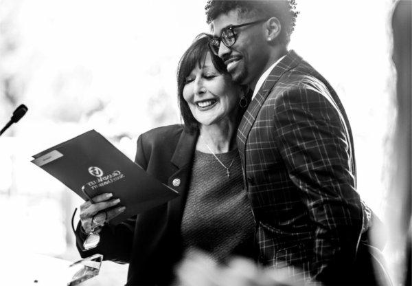  A college president hugs a student speaker. 